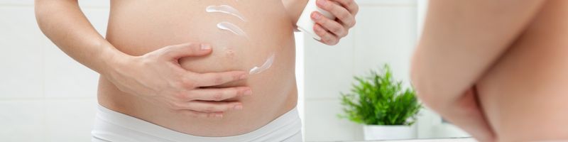 femme enceinte s’appliquant un lait pour le corps