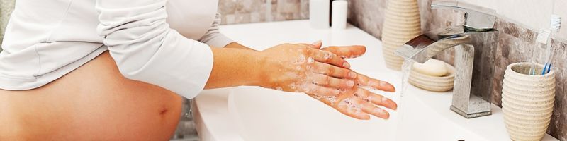 femme enceinte se lavant les mains avec un savon bio