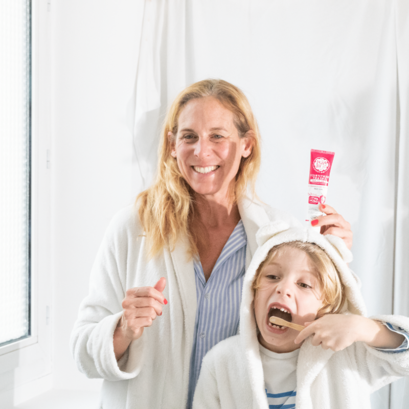 child brushing his teeth with a wooden toothbrush