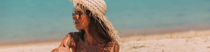 femme qui bronze sur une plage en plein soleil